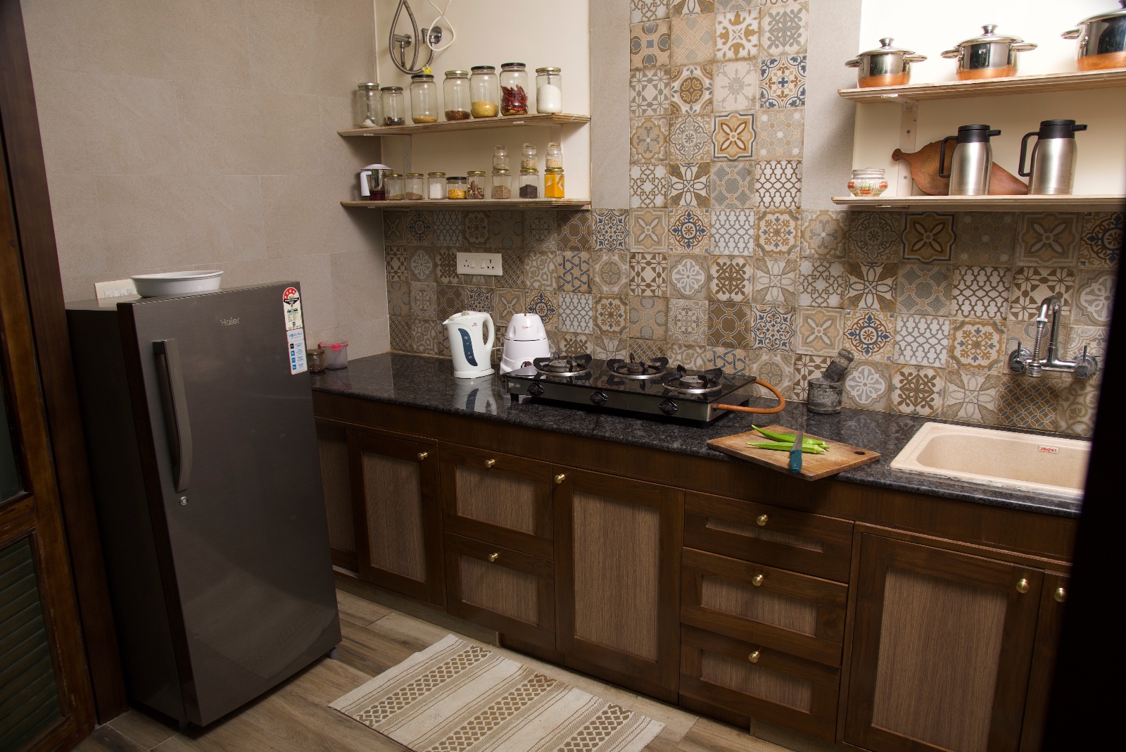 Kitchen with a refrigerator, gas stove, sink and patterned tile backsplash